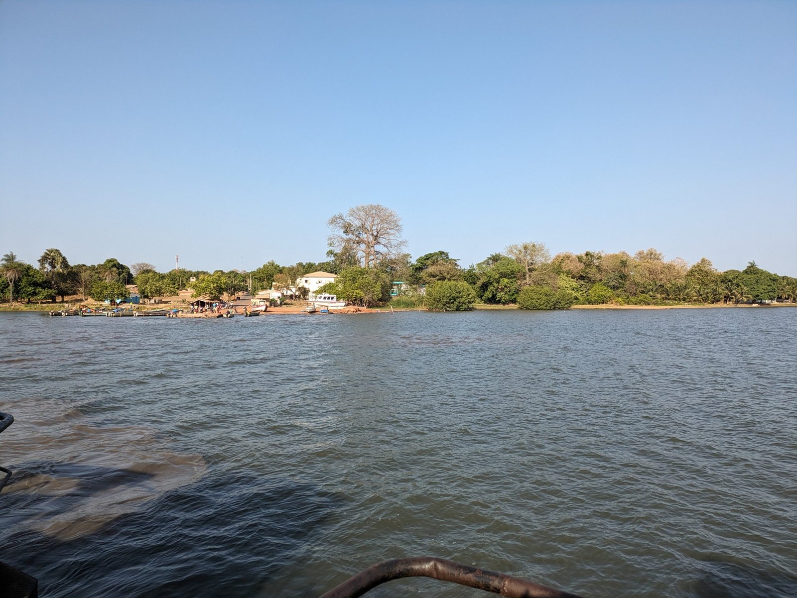 Quai fluvial sénégalais avec embarcations amarrées sous un ciel clair